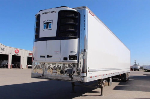 A refrigerated trailer with its cooling unit parked at a transport depot.