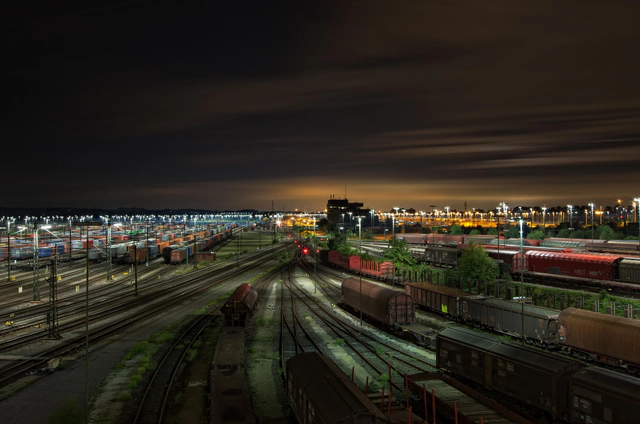 Freight trains and rail tracks illuminated at night.